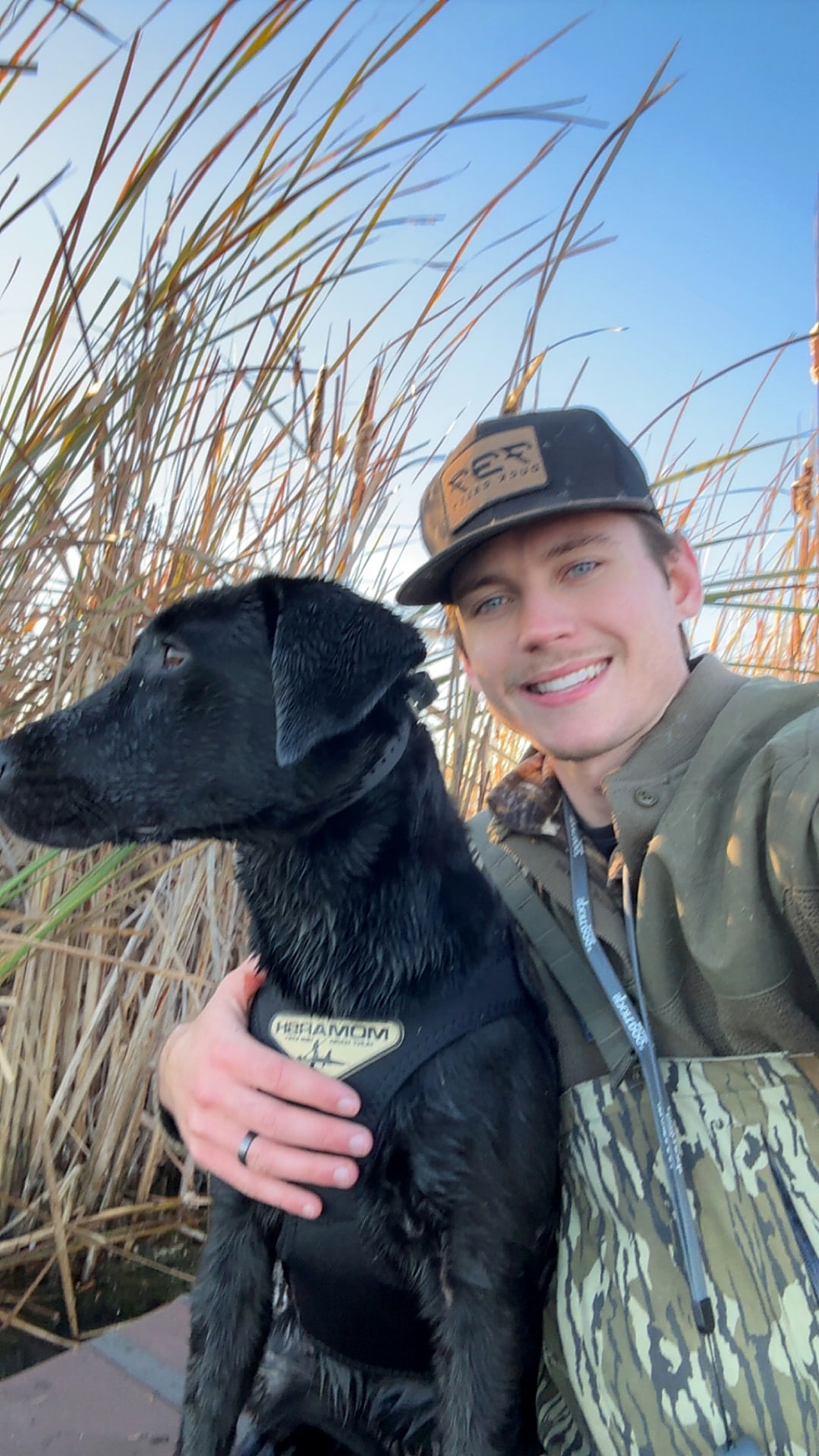 Ethan Starnes in the field with his retriever.